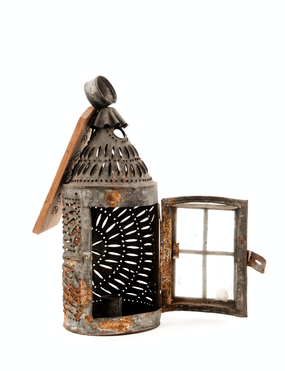 Perforert blekksylinder med glasdør og handtak.

