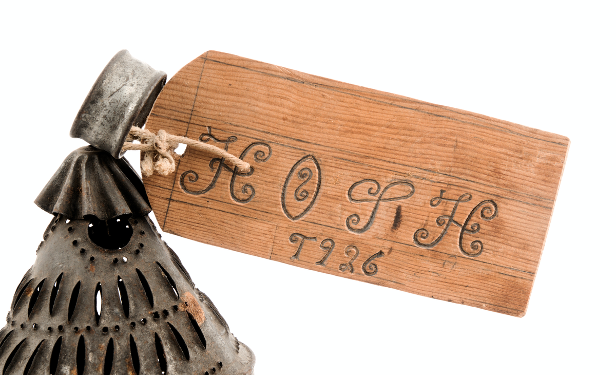 Perforert blekksylinder med glasdør og handtak.

