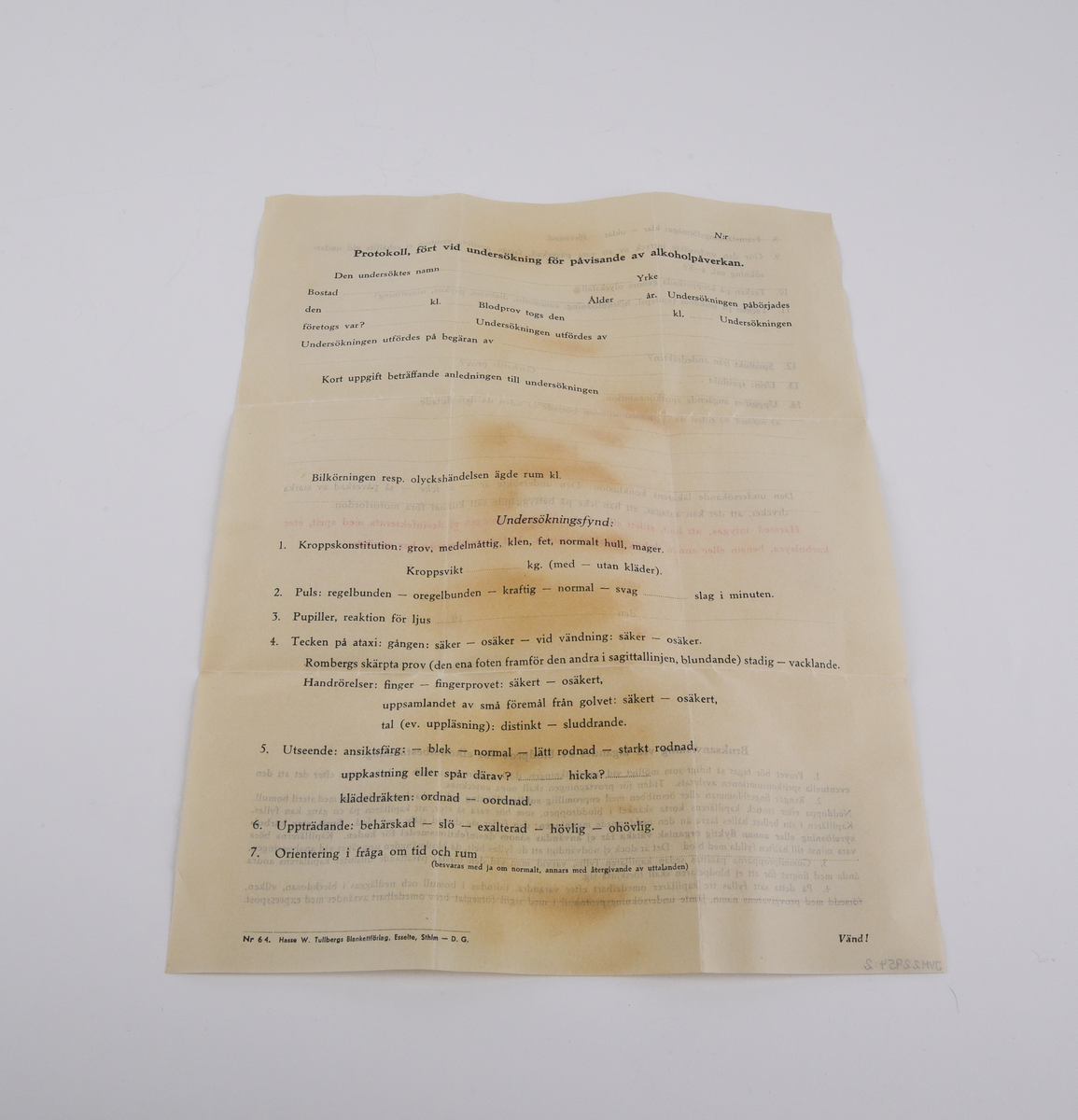 Kuvert med provtagningsset för blodprov för alkoholanalys med tillhörande protokoll.
Rektangulärt, brunt kuvert (:1) med text i svart som lyder "Express Till Statens Rättskemiska laboratorium Lindhagensg 126 Stockholm".
Protokoll (:2) som fylls i vid undersökningen. Rubriken lyder "Protokoll, fört vid undersökning för påvisande av alkoholpåverkan." Protokollet avslutas med en "Bruksanvisning vid tagandet av blodprov för alkoholbestämning.".
Ask i plåt (:3) med etikett på locket. Etikettens text i svart lyder "Blodprov för alkoholanalys från ... taget den ... kl. ... av ...". Asken innehåller bomull som skyddar tre glasrör och sex gummidetaljer.
