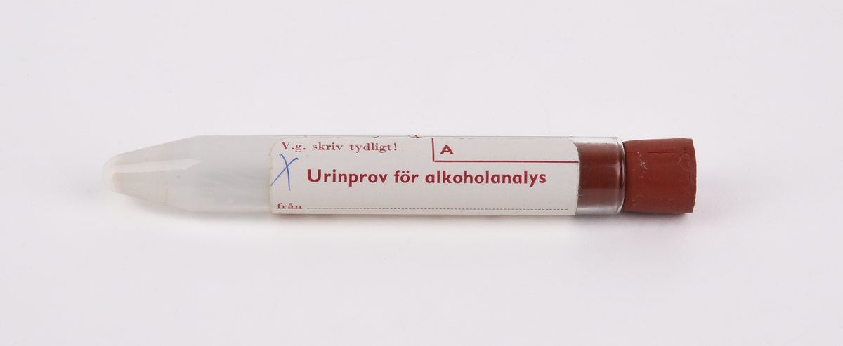 Rör av brun papp i två delar (:1-2). Inuti röret finns ett provrör av glas (:3) som försluts med en kork av rött gummi (:4). Provrövet omsluts av ett ljusbrunt skyddspapper (:5). 
På provröret finns en vit klisterlapp. På lappen står "V.g. skriv tydligt! A Urinprov för alkoholanalys från taget den / 19 kl. av OBS! Röret är preparerat med fluorid!" Någon har ritat ett kryss med blått bläck i lappens övre vänstra hörn. På glasrörets röda gummikork återfinns siffran 16.