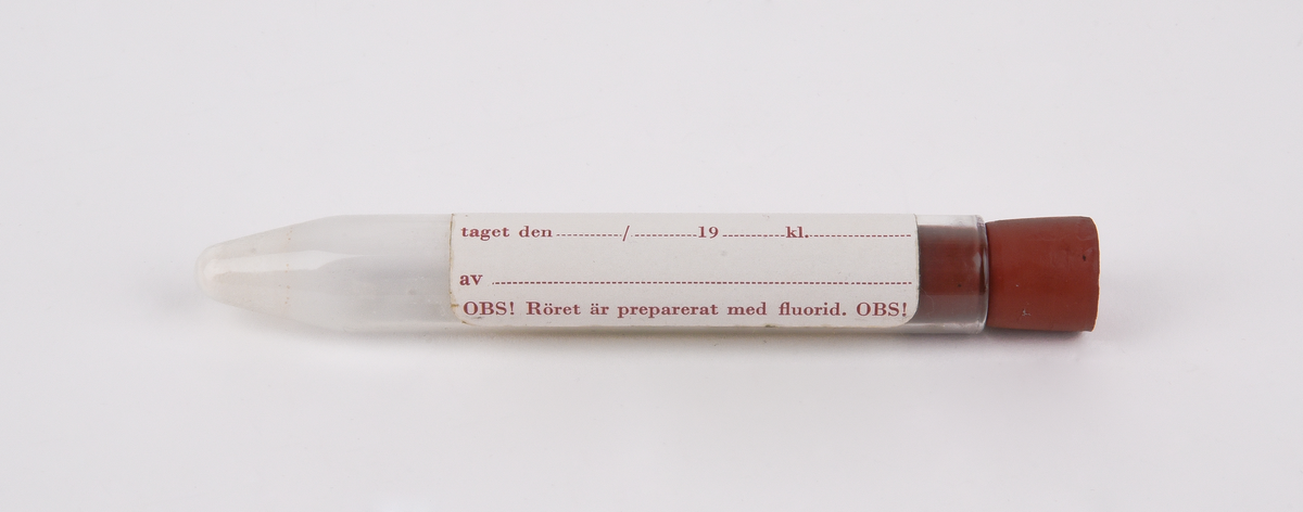Rör av brun papp i två delar (:1-2). Inuti röret finns ett provrör av glas (:3) som försluts med en kork av rött gummi (:4). Provrövet omsluts av ett ljusbrunt skyddspapper (:5). 
På provröret finns en vit klisterlapp. På lappen står "V.g. skriv tydligt! A Urinprov för alkoholanalys från taget den / 19 kl. av OBS! Röret är preparerat med fluorid!" Någon har ritat ett kryss med blått bläck i lappens övre vänstra hörn. På glasrörets röda gummikork återfinns siffran 16.