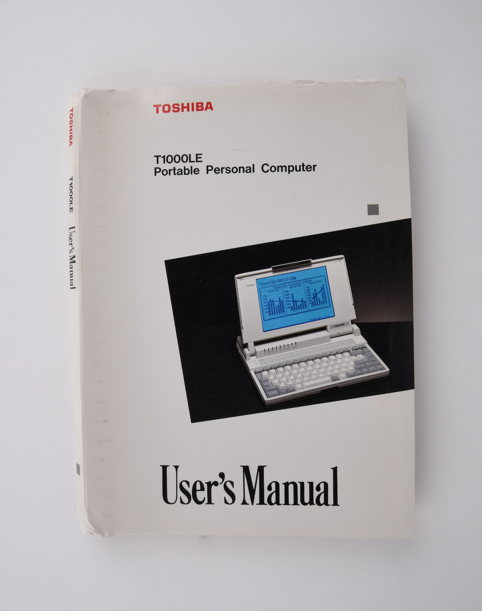 Bärbar dator (:1) Toshiba "T1000LE" av grå plast. Uppfällbar bildskärm som i uppfällt läge tillgängliggör tagentbordet med QWERTY-layout och svenska tecken. Löstagbar pappersremsa med kortkommandon ovanför tagentbordet. På sidan en port för 3,5-tums disketter. På baksidan en port till laddningsdocka (:2), även denna i grå plast. Laddningsdockan har ett flertal uttag till olika kablar, bland annat till en strömadapter (:3) i svart plast med tillhörande kabel. 
Två tillhörande 3,5-tums disketter (:4-5) även dessa från Toshiba. Med operativsystemet MS-DOS 3.3. Fyra tillhörande användarmanualer (:6-9). En manual med allmän information för den bärbara datorn på svenska. En manual för MS-DOS 3.3, en för den bärbara datorn och en för laddningsdockan, samtliga på engelska.