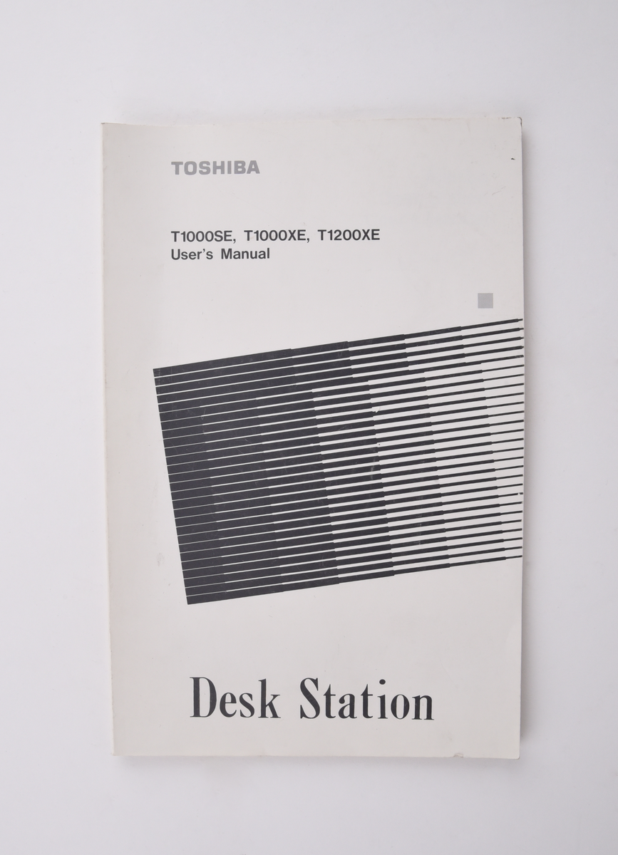 Bärbar dator (:1) Toshiba "T1000LE" av grå plast. Uppfällbar bildskärm som i uppfällt läge tillgängliggör tagentbordet med QWERTY-layout och svenska tecken. Löstagbar pappersremsa med kortkommandon ovanför tagentbordet. På sidan en port för 3,5-tums disketter. På baksidan en port till laddningsdocka (:2), även denna i grå plast. Laddningsdockan har ett flertal uttag till olika kablar, bland annat till en strömadapter (:3) i svart plast med tillhörande kabel. 
Två tillhörande 3,5-tums disketter (:4-5) även dessa från Toshiba. Med operativsystemet MS-DOS 3.3. Fyra tillhörande användarmanualer (:6-9). En manual med allmän information för den bärbara datorn på svenska. En manual för MS-DOS 3.3, en för den bärbara datorn och en för laddningsdockan, samtliga på engelska.