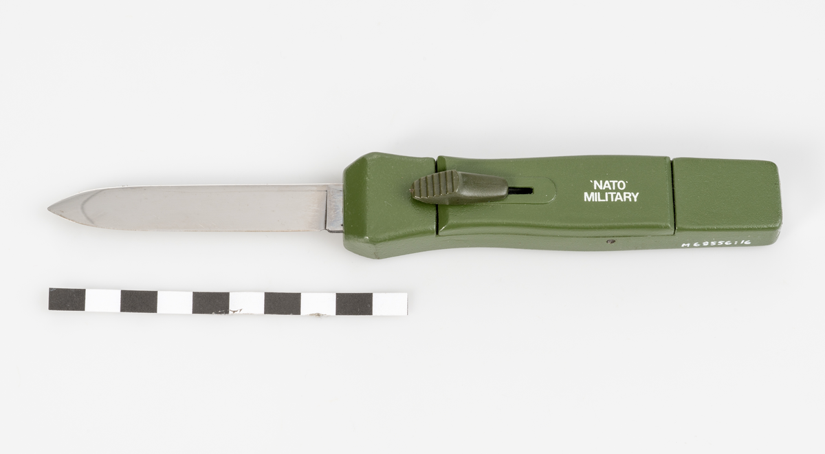 Stilettkniv. Knivblad i bajonettstil som frigörs framåt med skjutknappssystem. Militärgrönt knivskaft.