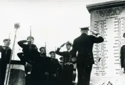 Admiral Briseid legg ned krans 21.08.1949 då minnesteinen i Telavåg over dei falne under andre verdskrigen vart avduka. Deltakarar frå Marinen står like ved i "giv akt".