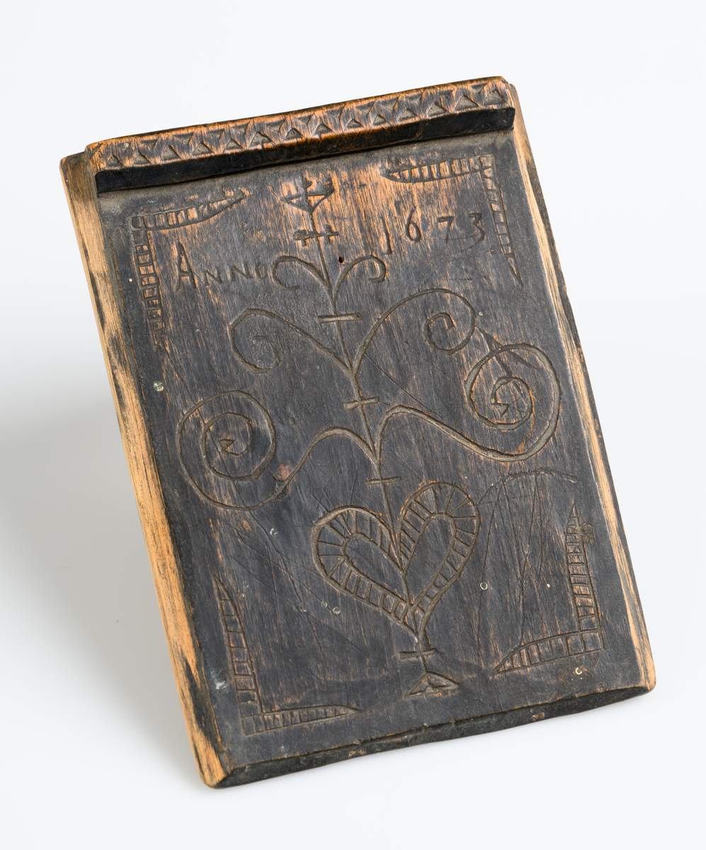 Trälåda, fyrkantig, med utskärningar och på locket årtalet 1673. Utskärningarna, framställa bladrankor av enahanda form, med ornamenterna å åtskilliga gravhällar i Västergötland (Husabytrakten) från den äldre medeltiden.