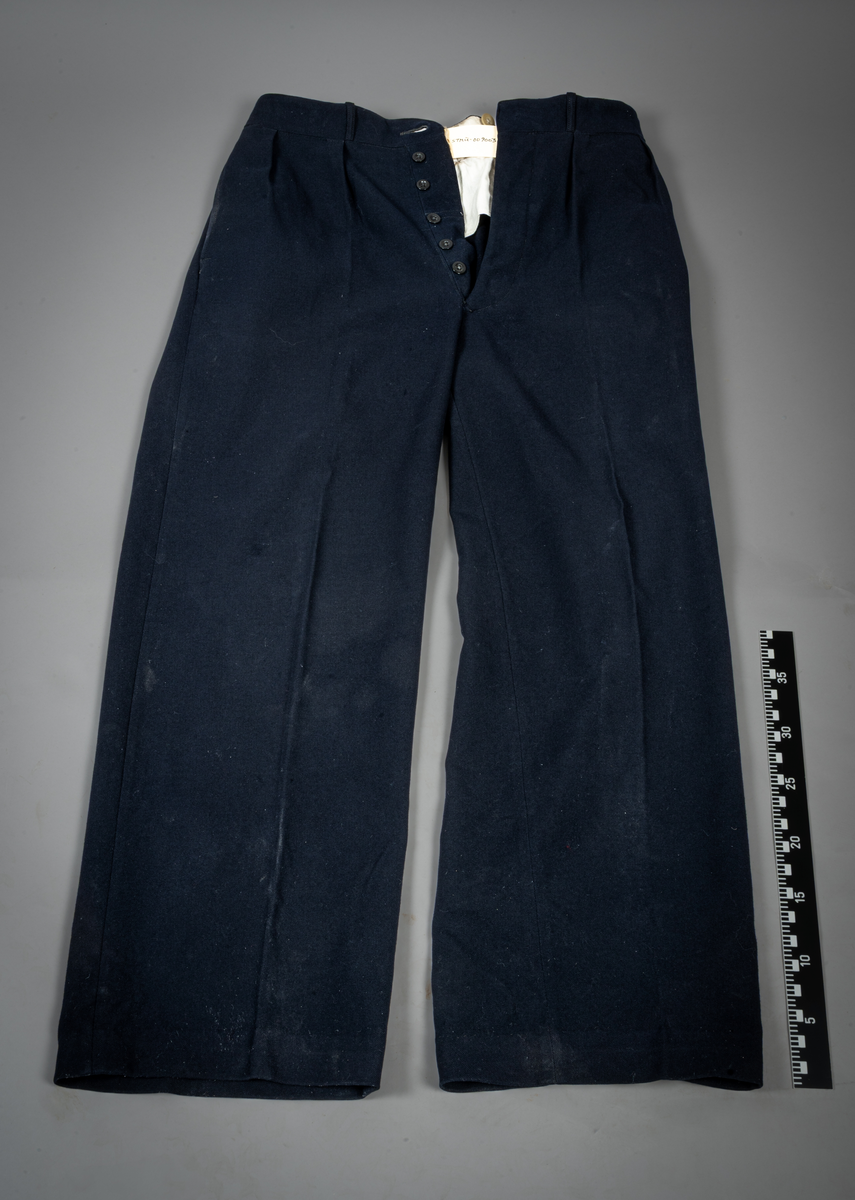Uniformsbukse tilhørende til uniformsjakke med registreringsnr. LSO 2319 (STMU-009002). Buksen har to bak- og forlommer. Buksesmekken har fire knapper i sort plast med fire syhull, på høyresiden. En knapp øverst på venstresiden. Innvendig rundt bukselinningen er seks store beige knapper i plast med fire knappehull.