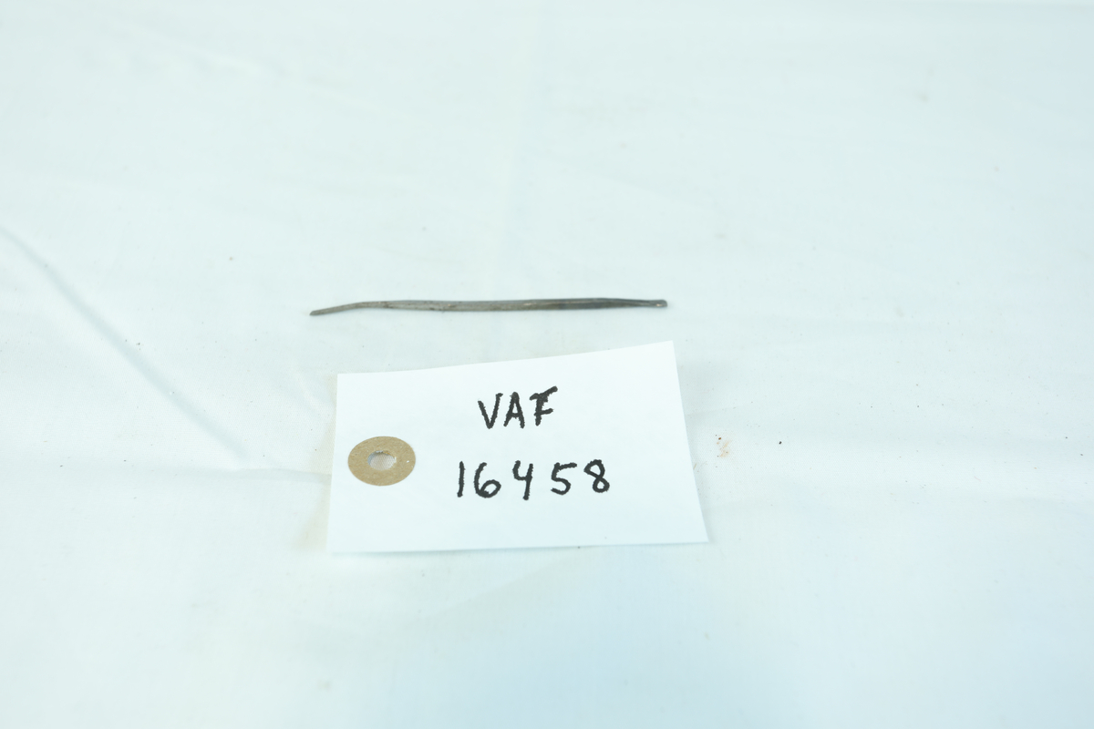 Avlang metallgjenstand som er tynn og med en svak bøy på den ene siden.