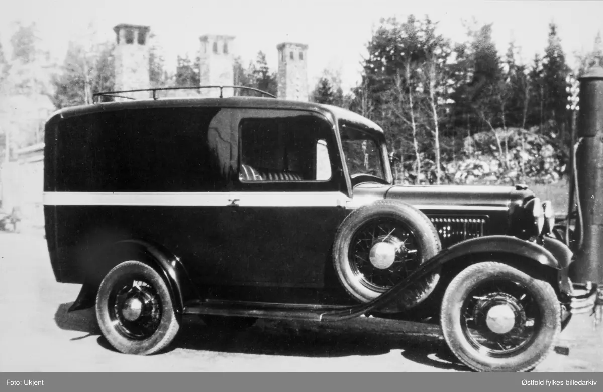 Varebil. Ford 1932. Tørkeribygningen på Kambo med de tre karakteristiske skorsteinene til venstre. Bensinpumpe til høyre.