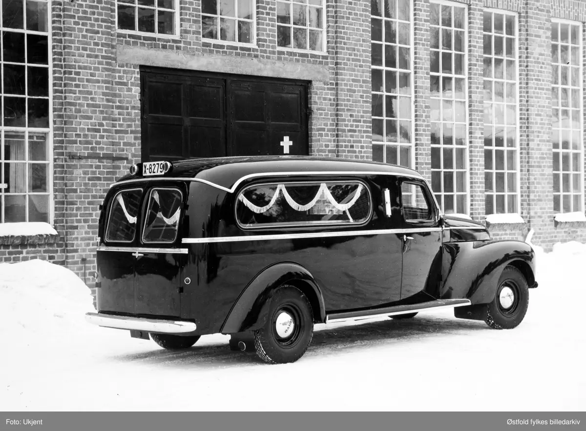 Bårebil eller bregravelsesbil med bilkjennetegn X-8279 parkert utenfor Auto-Karosserifabrikken, Kambo, Moss.