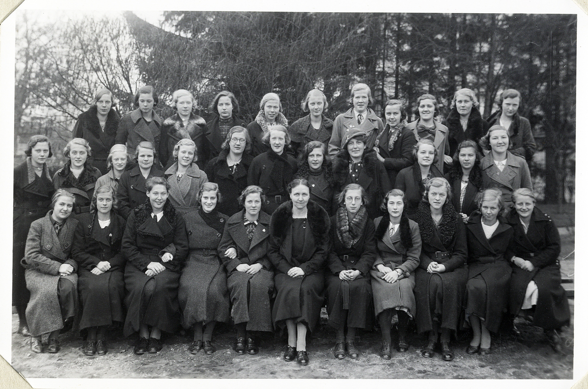 En skolklass från flickskolan, Växjö, 1935.
Text bredvid fotot: "Klass VIII 8 -35, med Fröknarna Lundgren o Wallin. 
1:sta (understa raden) fr.v. t. h. Ingrid Nyrén, Maj Norlén, Brita Österling, Brita Elmdahl, Siri Andersson, fr. Lundgren, Cecilia Borelius, Gunborg Nordmark, Ulla Fornander, Kerstin Friman, Ulla Eek.
2:dra raden,
Kerstin Nilsson, Ingrid Ahlberg, Margit Björsell, Karin Lindblom, Karin Sjölin, Ingrid Jonsson, Ingeborg Melin, Inga Welander, fr. Wallin, Anna-Brita Isaksson, Marianne Sjödahl, Birgit Linder.
3:dje raden,
Eva Westberg, Birgit Hjelmkvist, Ingrid Berglöf, Gunhild Ernstsson, Ingeborg Andersson, Sonja Davidsson, Margareta Andersson, Maj Fehrnström, Gunvor Svensson, Greta Pettersson, Birgit Landberg".