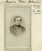 Porträtt av Johan Bengtsson i Byckorp i Ask socken. Tillsammans med sin bror Lars August kom han att ärva gården efter faderns bortgång 1845. Samma år ingick Johan äktenskap med Maria Mathilda Germundsdotter, bördig från Vadstena. Med tiden köpte makarna ut brodern och blev ensamma ägare till den relativt stora gården. Paret välsignades med dottern Maria Christina Mathilda, född 1848, och sonen Johan August, född 1854. Fotografiet tillkom uppskattningsvis omkring 1875.