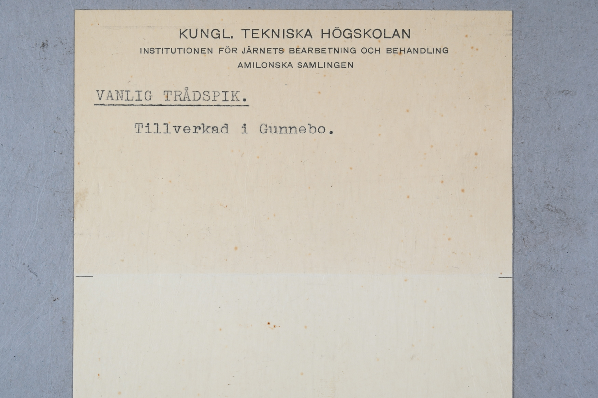 12 prover på trådspik. Tillhörande lapp med notering: "Vanlig trådspik. Tillverkad i Gunnebo."