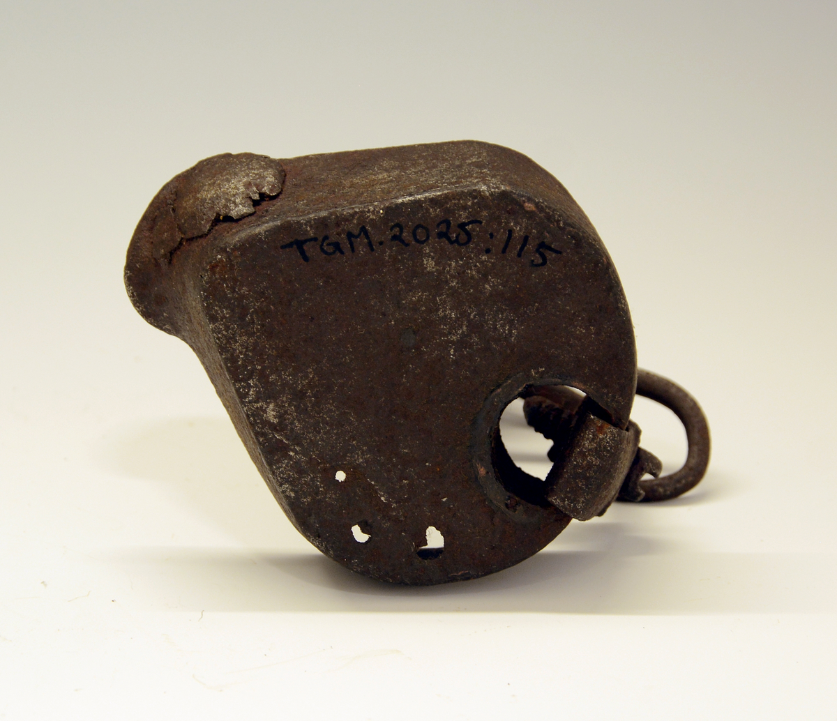 Tranlampe av jern, håndsmidd. Skålen med leppe foran og fold for hanken bak, hanken festet med nagle og mutter. Skjoldformet navneplate øverst.