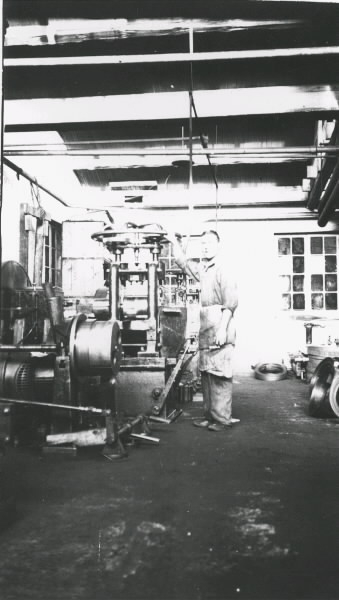 Arbetsplatsinteriör från Monarks cykelfabrik som visar män i produktionen. John Johansson arbetade en tid från sent 1930-tal som cykelarbetare.
