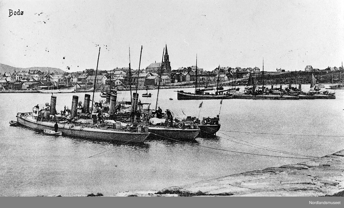 Postkort av havna i Bodø med tre torpedobåter. Kirken midt i bildet. Stemplet 04.09.1911.