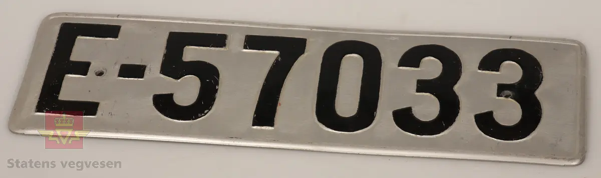 Bilskilt / bil kjennemerker:

- E - 60 8348. Grått skilt. Svart skrift. 
- E - 6477 Hotellvogn. Grått skilt. Svart skrift.
- B - 66958. Grått skilt. Svart skrift. 
- C - 5210. Grått skilt. Svart skrift. 
- C - 727143. Grått skilt. Svart skrift.
- D - 36862. Grønt skilt. Hvit skrift. 
- E - 70167. 2 stk helt likte. Grå. Svart skrift. Buet i form. Trolig sittet på motorsykkel. 
- E - 5050. Grått skilt. Svart skrift. Lagd for drosje. 
- E - 10101. Grått skilt. Svart skrift. 
- D - 1962. Grått skilt. Svart skrift. 
- D - 502139. Grått skilt. Svart skrift.
- E - 6172 Rutevogn. Grått skilt. Svart skrift.
- E - 10722 Leievogn. Grått skilt. Svart skrift. 
- E - 8487. Grått skilt. Svart skrift. 
- X - 69740. 2 stk helt like. Grått skilt. Svart skrift. 
- E - 61144. Framside hvit med rød skrift. Baksiden grønn.
- E - 79195. Grønt skilt. Hvit skrift. 
- E - 11299. Mørk grønt skilt. Hvit skrift. 
- S - 14 674. Grønt skilt. Hvit skrift. 
- F - 38 390. Grått skilt med grønn bakside. Hvit skrift. 
- Z - 56437. 2 stk helt like. Grått skilt. Hvit skrift. 
- E - 70167. Grått skilt. Svart skrift. 
- E - 10237. Grått skilt. Svart skrift. 
- Z - 93772. Grått skilt. Svart skrift.
- X - 62182. Grått skilt. Svart skrift.
- E - 12582. Grått skilt. Svart skrift. 
- E - 57033. Grått skilt. Svart skrift. 
- E - 69728. Grått skilt. Svart skrift. 
- E - 69905. Grått skilt. Svart skrift.
- A - 9444. Grått skilt. Svart skrift. 
- F - 81212. Grått skilt. Svart skrift. 
- C - 2055. Grått skilt. Svart skrift.
- S - 36887. Grått skilt. Svart skrift.
- K - 93482. Grått skilt. Svart skrift.
- I - 4332. Grått skilt. Svart skrift.
- H - 607551. Grått skilt. Svart skrift. 
- T - 49877. Grått skilt. Svart skrift. 
- W - 61974. Grått skilt. Svart skrift. 
- V - 73267. Grått skilt. Svart skrift. 
- U - 92620. Grått skilt. Svart skrift. 
- U - 90282. Grått skilt. Svart skrift. 
- U - 5055. Grått skilt. Svart skrift. 
- T - 90039. Grått skilt. Svart skrift. 
- T - 16746. Grått skilt. Svart skrift. 

