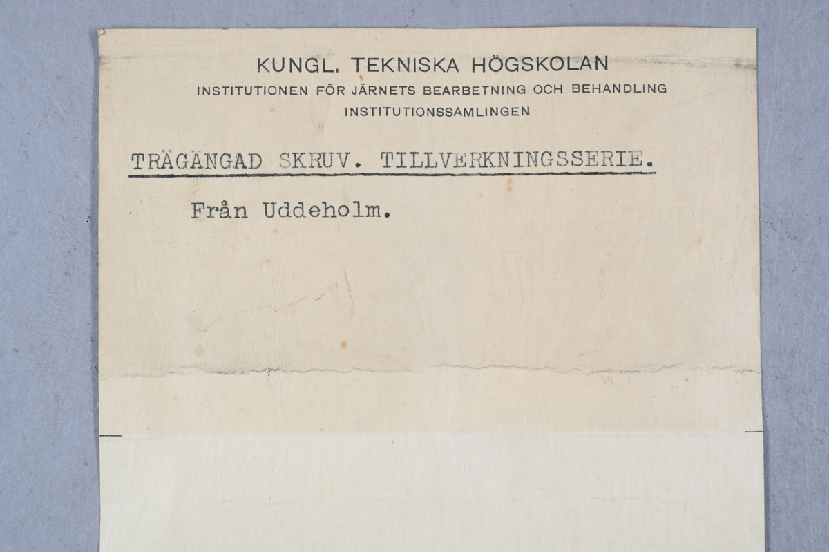 Tre prover på trägängad skruv. Tillhörande lapp med notering: "Trägängad skruv. Tillverkningsserie. Från Uddeholm."