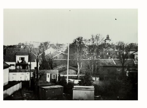 "Torgvagnar uppställda på Isaksens gård 1932." Vy med Varbergs kyrka i bakgrunden.