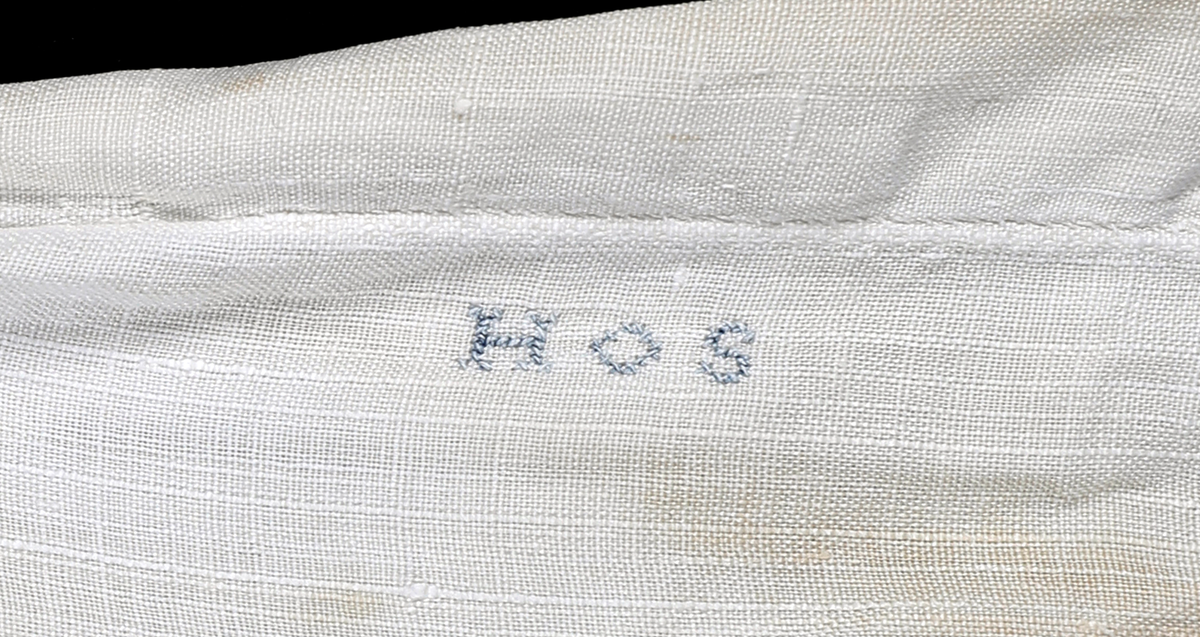 Løsermer med mansjett i begge ender med hvitsømsbroderi. Stripet ved mansjettene. Smal indresøm mellom splittene ved mansjettene. Spesielt godt håndverk.