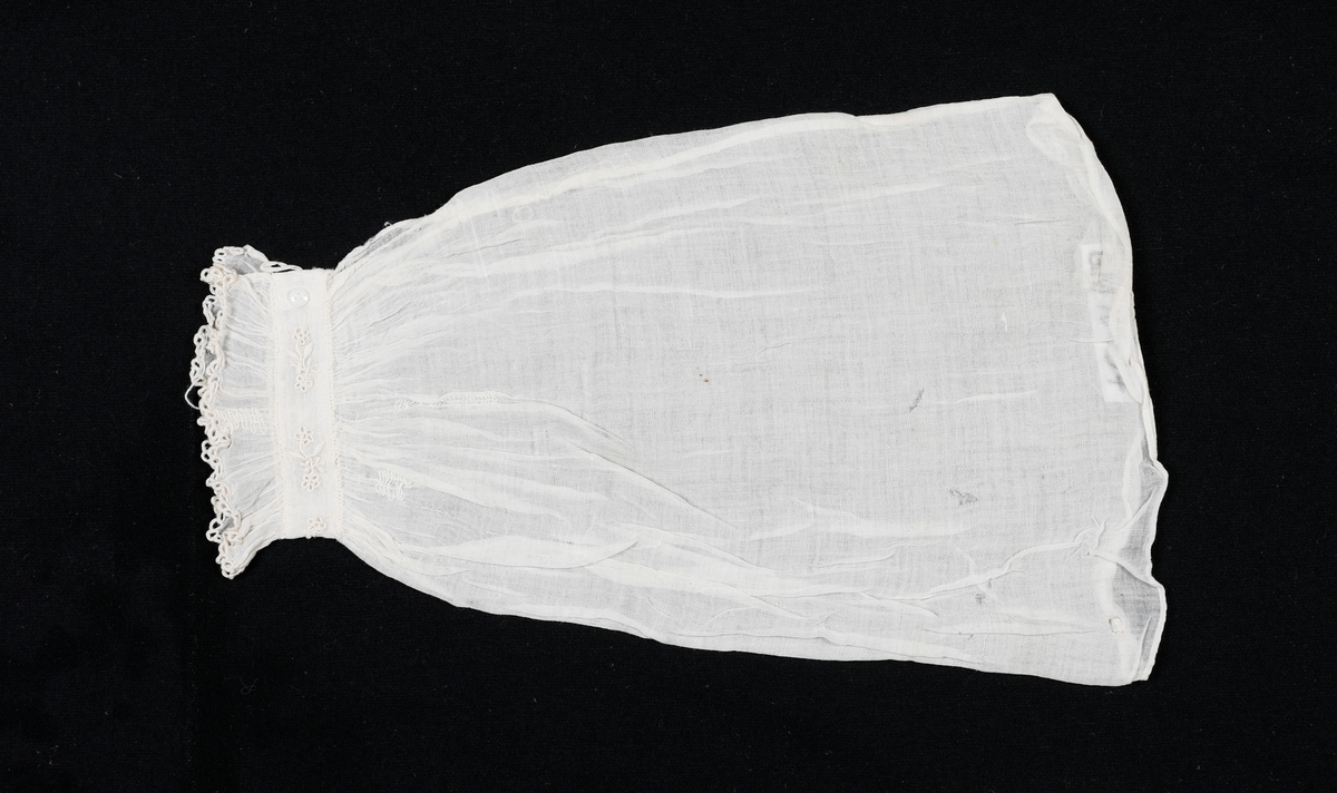 Løserme i tynt stoff. Rynket over og under mansjettlinning. Mansjettlinningen er brodert. Lukkes med hempe og en liten knapp. Sidesømmen i ermet er indresøm. Lappet noen steder. 