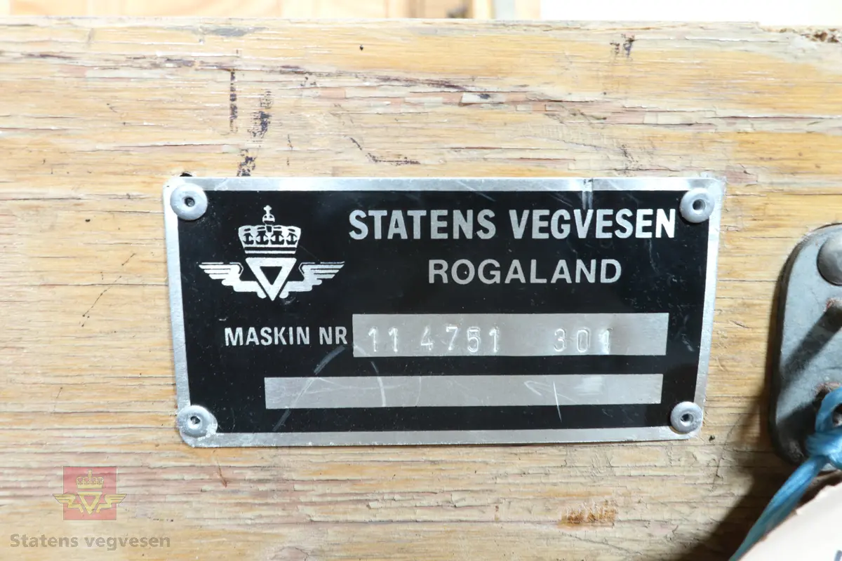 Trekasse med lokk som inneholder metallbjelker og forskjellig måleutstyr. Innvendig i lokket er det festet en produksjonstegning av bjelkene.