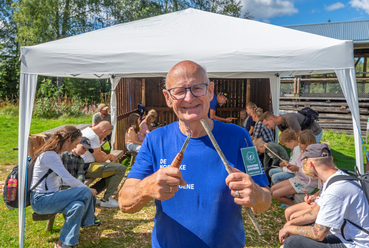 Spikkeaktiviteter for barn på Knivtorget under De Nordiske Jakt- og fiskedager 2025, et arrangement i regi av Anno Norsk skogmuseum i Elverum, Innlandet. Jakt- og fiskedagene. Sjefsspikker Arne Fjeld i forgrunnen. Spikking med kniv. Dnjfd 2025.