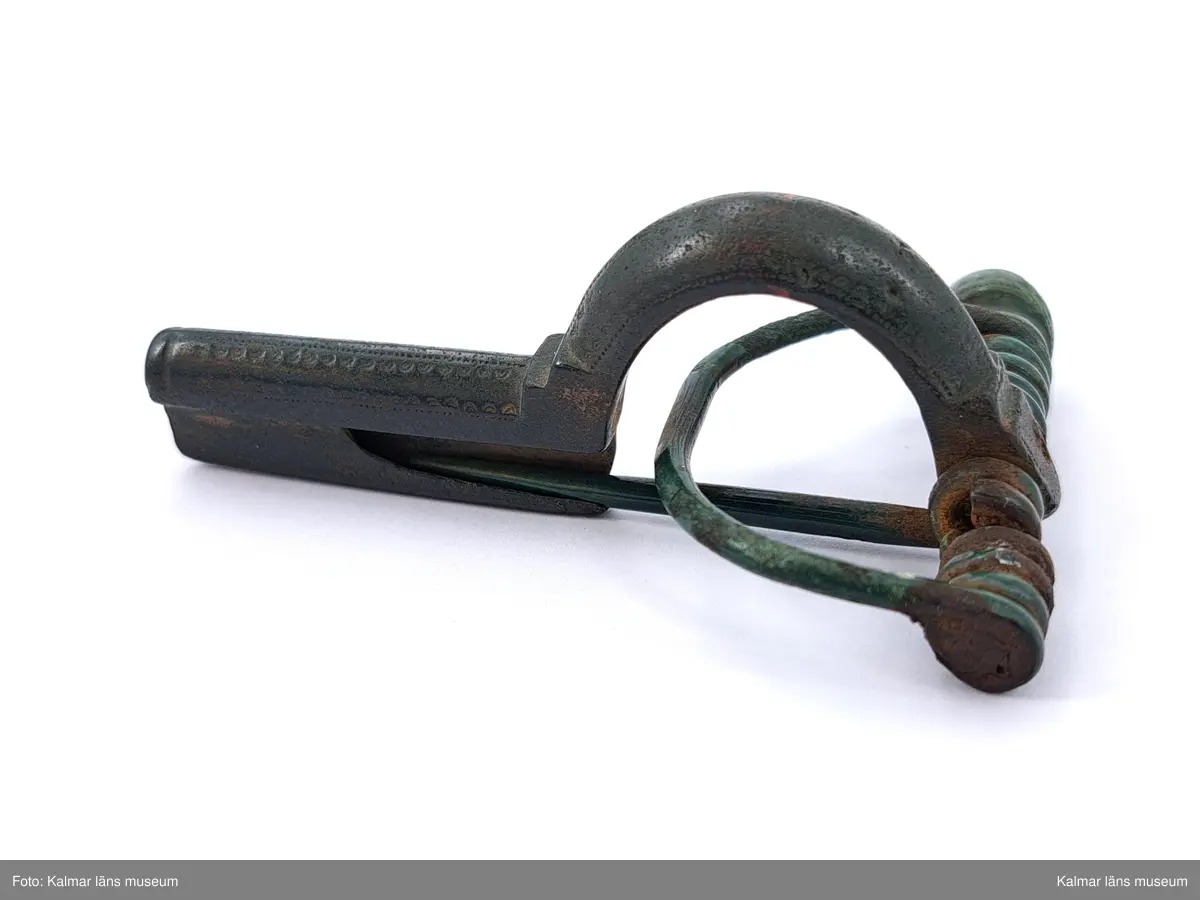 KLM 131. Fibula, armborstfibula. Gjuten av brons. Båge och fotstycke ornerade med fyra längsgående rader inpunsade koncentriska halvcirklar, två på vardera sidan om ryggen. Fotstycket slutar tvärt och nålhylsan är delvis sluten. Tvärstångens ena knopp fattas.