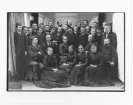 Reprofotografi. Kungliga Hantverksskolan för blinda i Kristinehamn Värmland ( vid korsningen Västerlånggatan-Tegelslagaregatan).
Elever och lärare vid Blindskolan. Sittande fr v  Fredrik Westblom, lärare, Sven G Sikström, föreståndare, Sofie Louise Halldin, lärare, J l Nygren ( med polisonger.