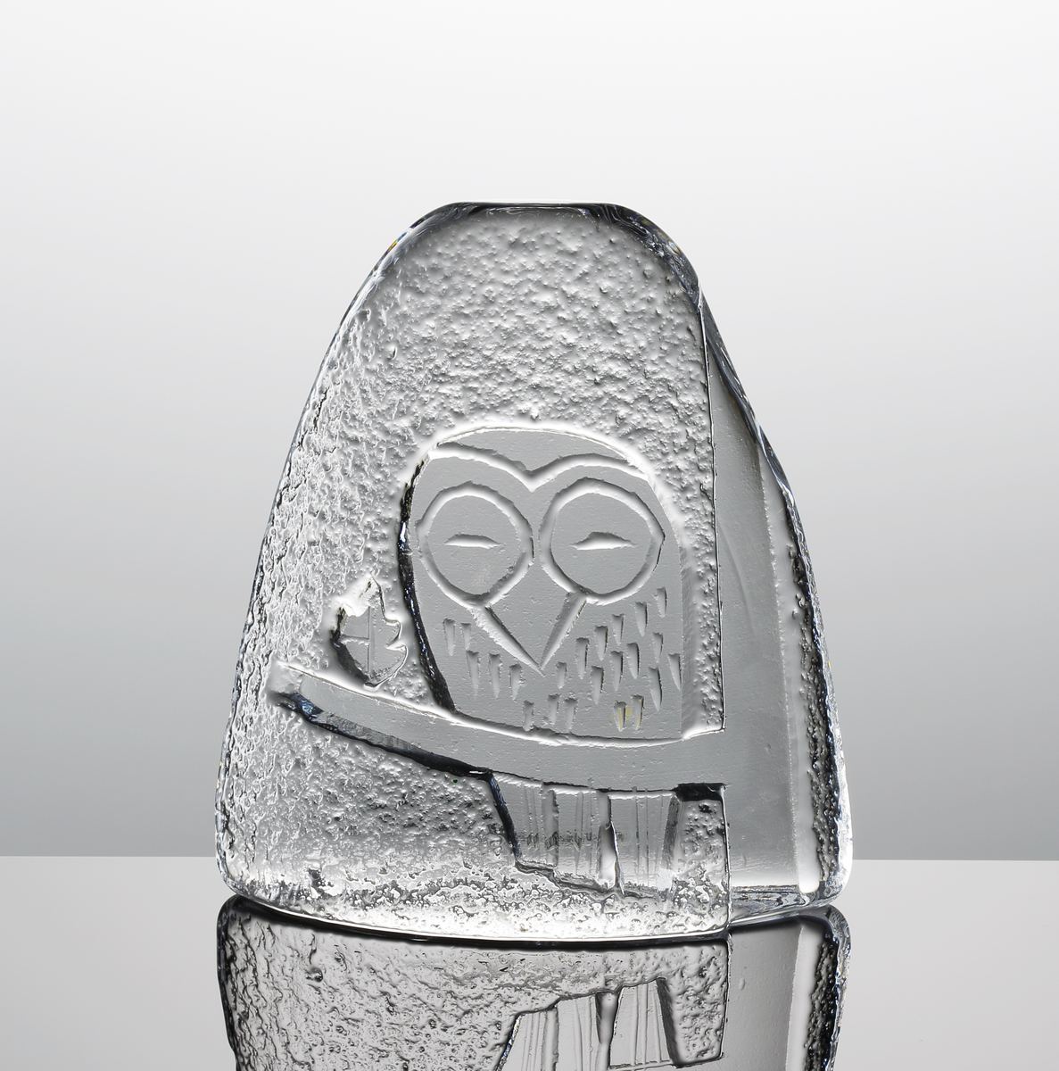 Glasblock med motiv av en uggla på en gren. Klisterlapp på baksidan: "FULL LEAD CRYSTAL". I botten ett etsat företagsmärke och texten "SKRUF SWEDEN".