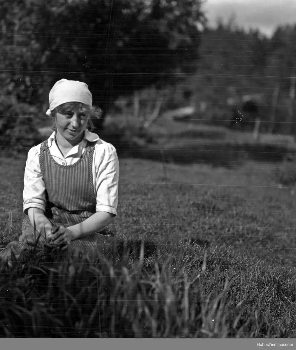 Kvinna sittandes på gräsmatta.
