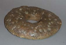 Gipsavgjutning av brödet Mandelkrans, ursprungligen 11 stycken. Rund med hål i mitten, naggad. Bruksslitage. 