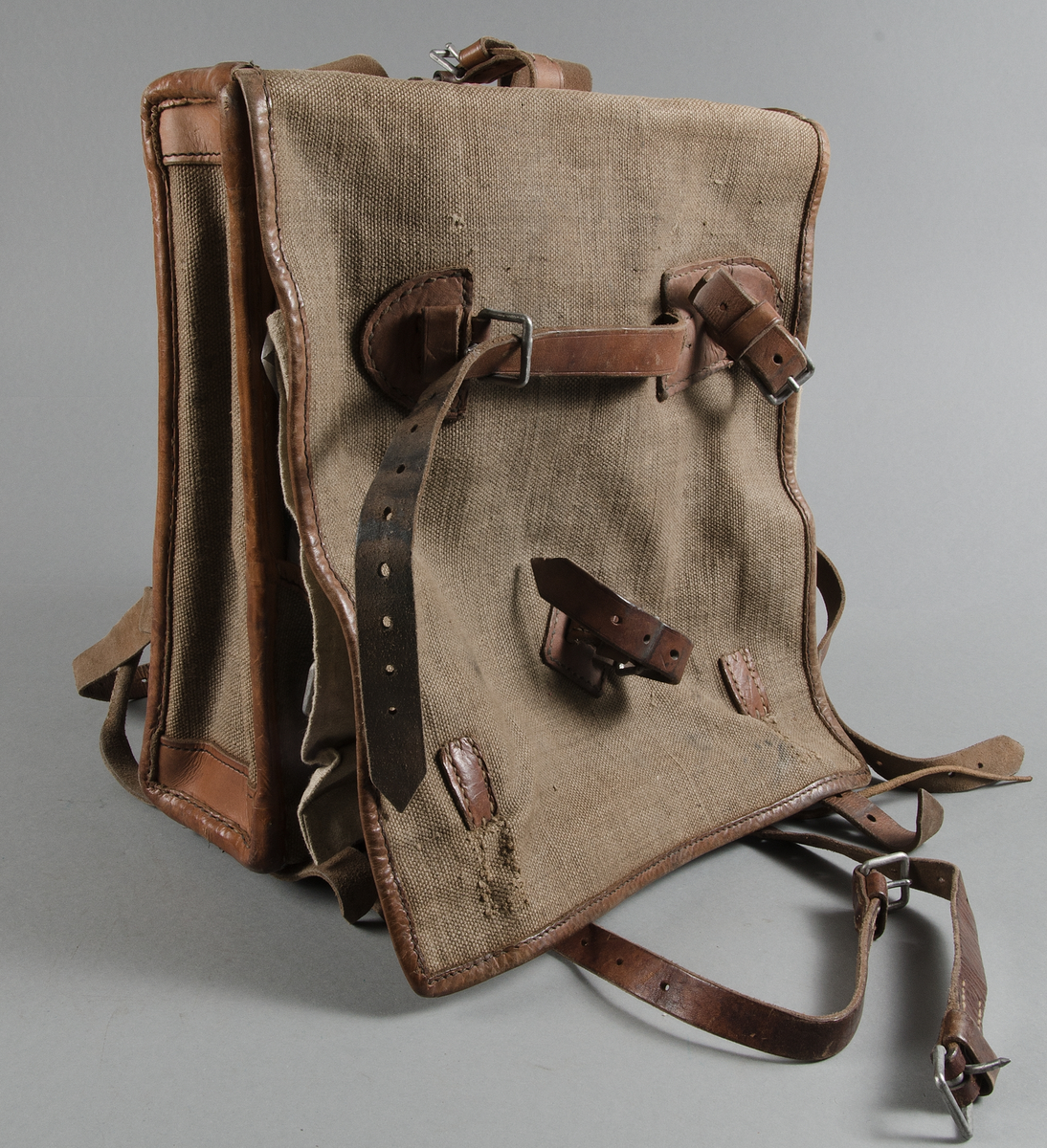 Ränsel m/1905. Av grov tuskaftad väv, hampa? och brunt läder. Läderremmar och järnspännen.
