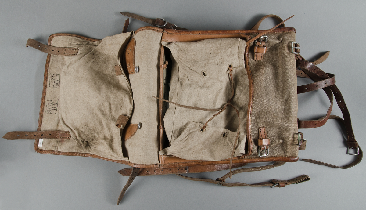 Ränsel m/1905. Av grov tuskaftad väv, hampa? och brunt läder. Läderremmar och järnspännen.