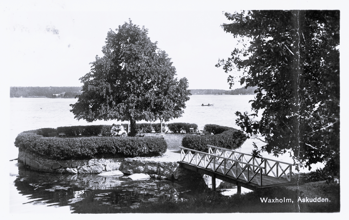 Foto av Askudden, Vaxholm. Text vid bild i album: "Stekpannan i Vaxholm".
Text på baksidan kort: "Vaxholm d. 22/5-1926. Kära lilla Greta. En glad pingsthelg tillönskas Dig från oss alla. Tack för telegrammen, Ejnar gifter sig idag, Knutte och Margit är med på bröllopet. Vi må bra. Hälsa fru Svensson. Hjärtliga hälsningar från oss alla. Farbror Knut".