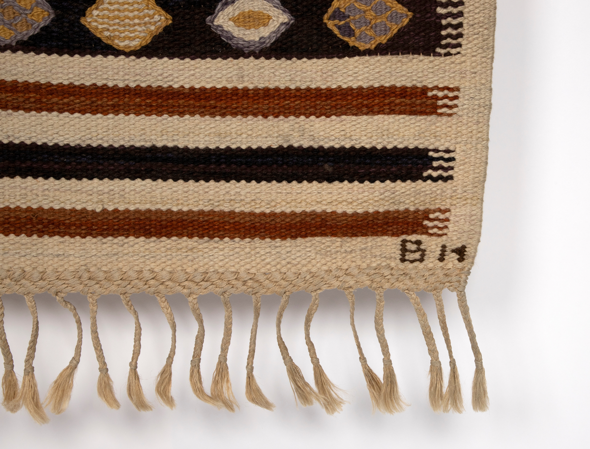 Gulvteppet vevd i röllakanteknikk. Lingarn i renningen og nauthårsgarn i innslaget. Stripet i hvitt, rødbrunt og brunsvart i innlagsretningen, sju smale striper veksler med en bredere stripe hver 25. cm. I de brede stripene er det vevd inn spissovale former med hvitt, lilla og gult fylldekor bestående av avvekslende flekker, striper og spissovaler. På langsidene en 3 cm bred jarekant i hvitt. I teppets kortender er det knyttet frynser av renningen.