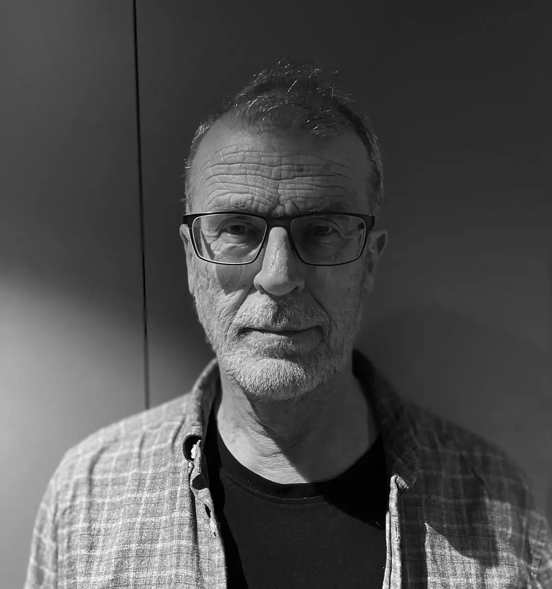 portrettbilde av Sveinung Nordstoga i rutete skjorte i svart kvitt bilde