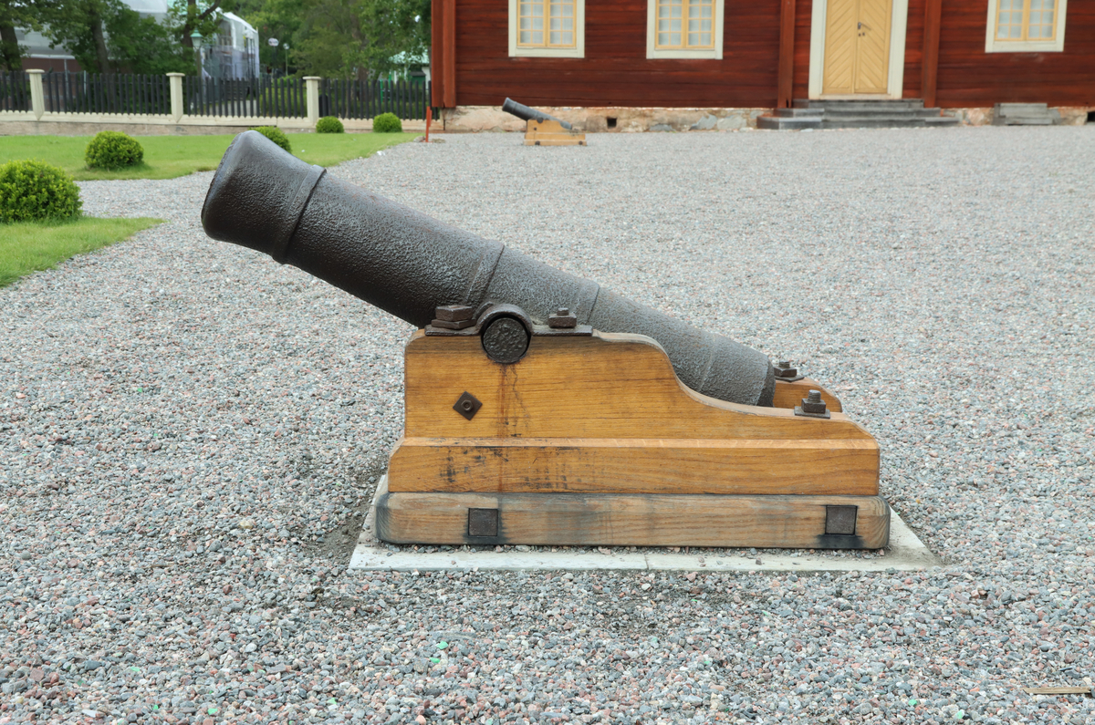 Kanon av järn monterad på nytillverkad lavett av ek, utan hjul. Gjuna band på var sida om axeln och kring bakstycket.