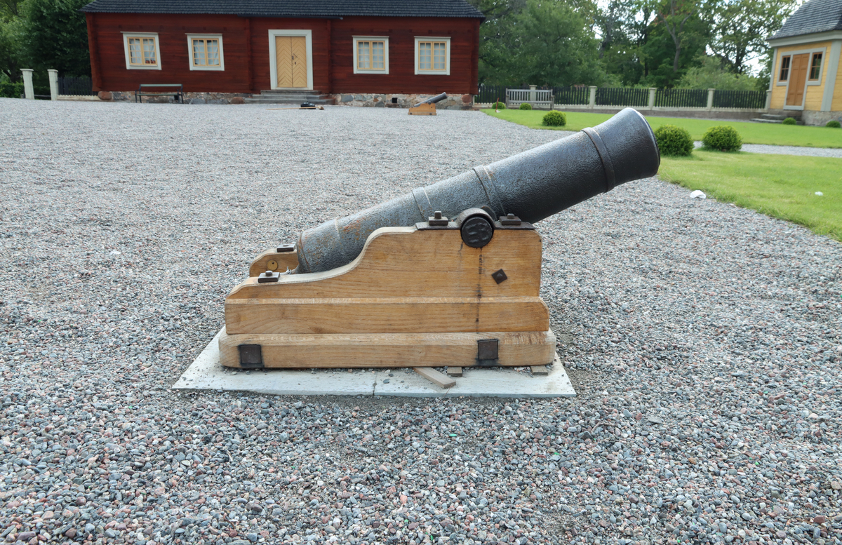 Kanon av järn monterad på nytillverkad lavett av ek, utan hjul. Gjutna band på var sida om axeln och kring bakstycket och en bit in från mynningen. Mynningen svagt utåtklockad. 