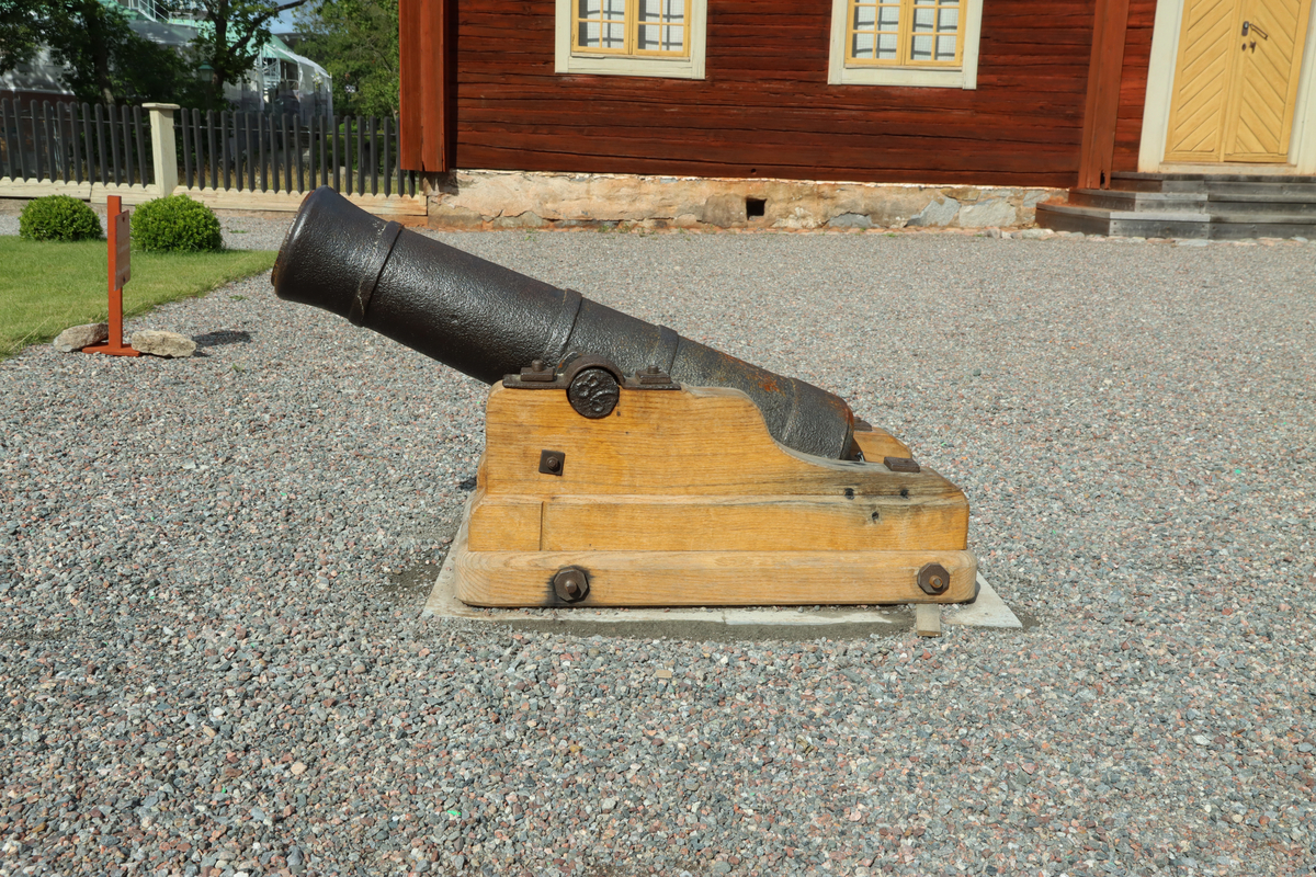 Kanon av järn monterad på nytillverkad lavett av ek, utan hjul. Gjutna band på var sida om axeln och kring bakstycket och en bit in från mynningen. Mynningen svagt utåtklockad. 
