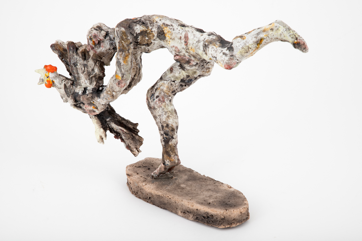 Figurativ keramisk skulptur med en naken mann som fanger en hane. Plassert på en oval base. Hovedmotivet er bevegelsen, spranget og flukten; det er et kraftfullt øyeblikk som er gjengitt. Menneskefigurens stilling er dynamisk, foroverlent, balanserende på en halv fot, med det andre beinet utstrakt bak seg. Hendene griper om en flaksende, liksom kaklende fugl med vingene utslått. Leiren er ekspressivt og røft modellert, noe som forsterker flyktigheten og farten i motivet. Hvit glasur ispedd flekker av oransje, gult og rosa er uregelmessig påført det ellers uglaserte godsets grå egenfarge. Basen er uglasert.