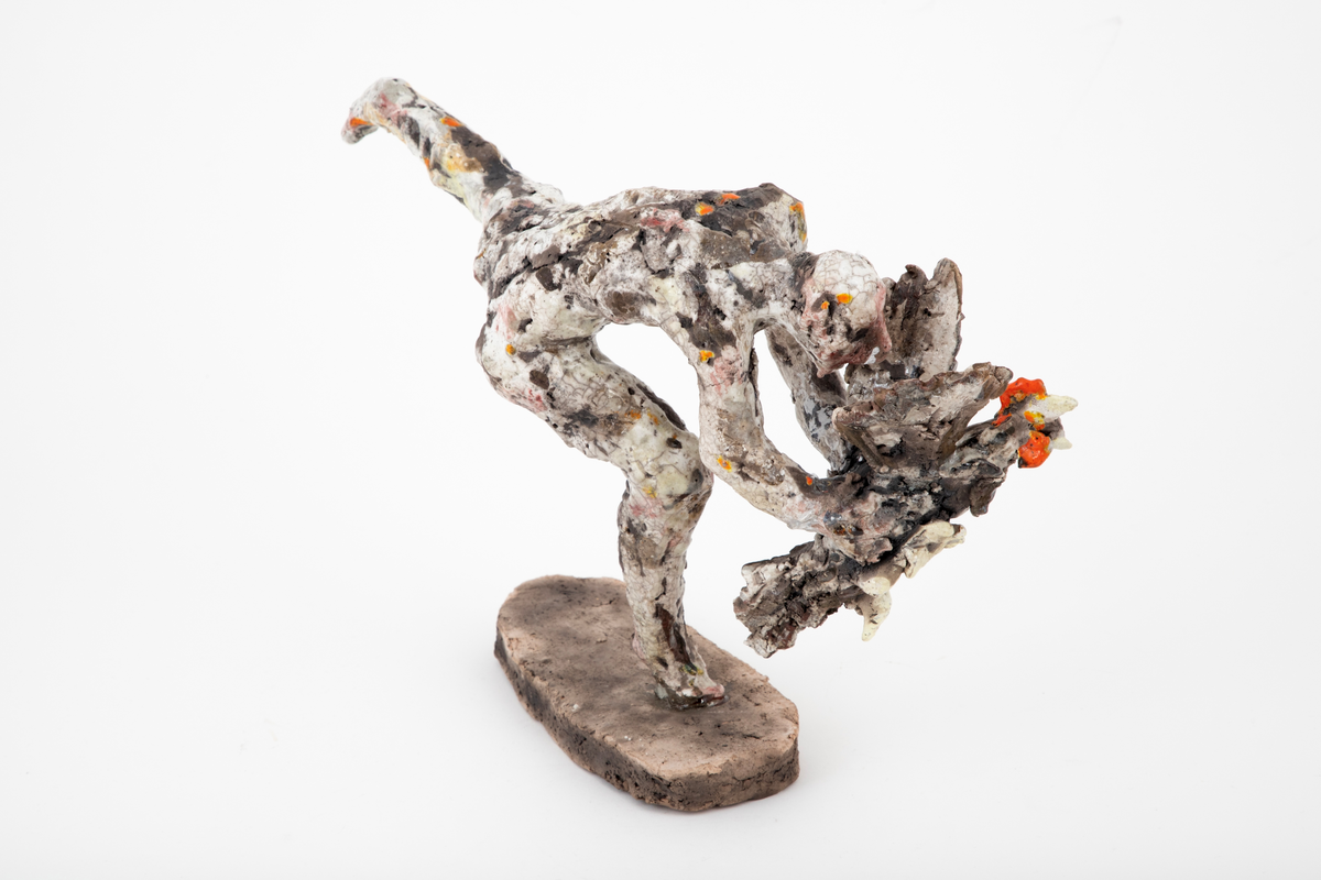 Figurativ keramisk skulptur med en naken mann som fanger en hane. Plassert på en oval base. Hovedmotivet er bevegelsen, spranget og flukten; det er et kraftfullt øyeblikk som er gjengitt. Menneskefigurens stilling er dynamisk, foroverlent, balanserende på en halv fot, med det andre beinet utstrakt bak seg. Hendene griper om en flaksende, liksom kaklende fugl med vingene utslått. Leiren er ekspressivt og røft modellert, noe som forsterker flyktigheten og farten i motivet. Hvit glasur ispedd flekker av oransje, gult og rosa er uregelmessig påført det ellers uglaserte godsets grå egenfarge. Basen er uglasert.