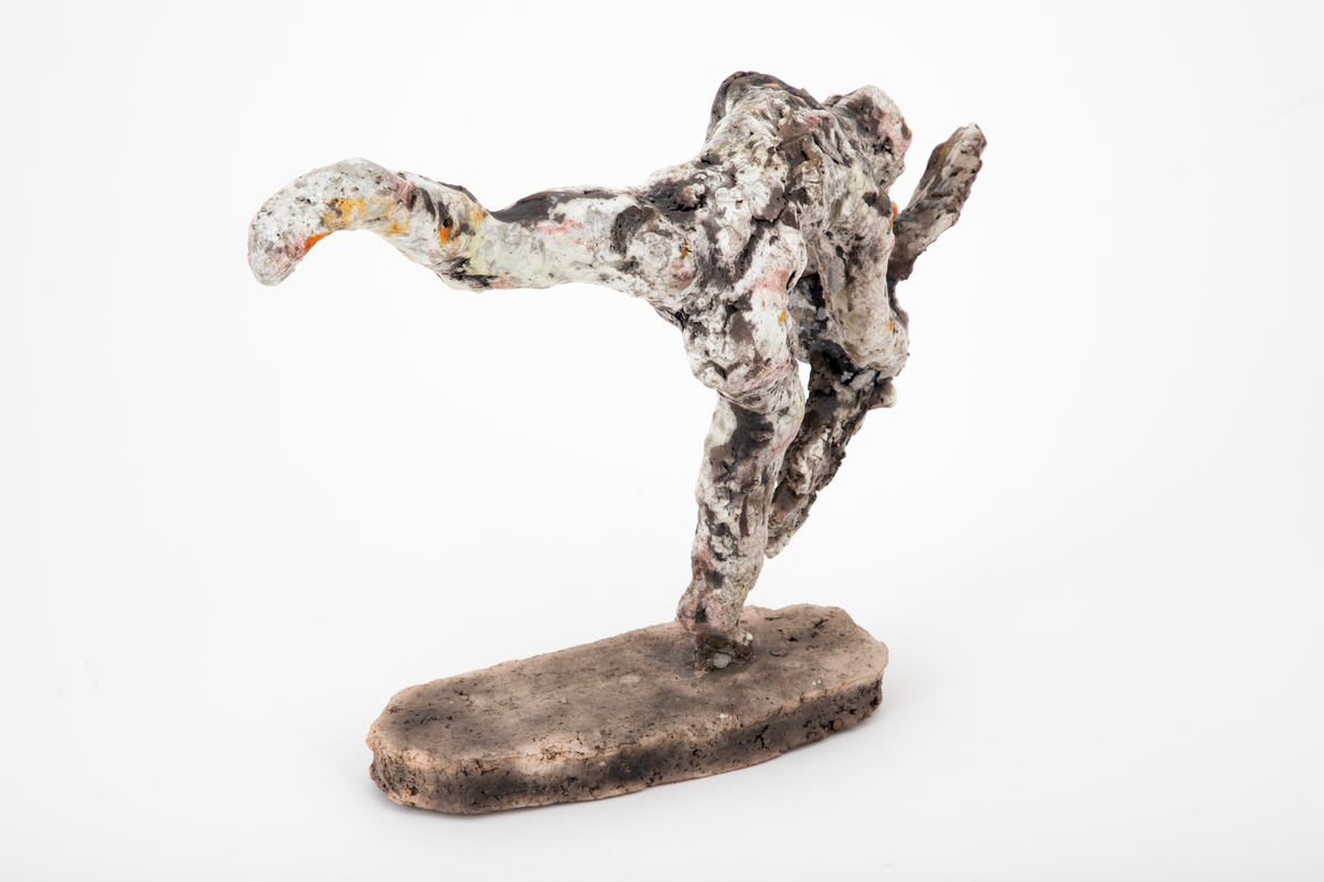 Figurativ keramisk skulptur med en naken mann som fanger en hane. Plassert på en oval base. Hovedmotivet er bevegelsen, spranget og flukten; det er et kraftfullt øyeblikk som er gjengitt. Menneskefigurens stilling er dynamisk, foroverlent, balanserende på en halv fot, med det andre beinet utstrakt bak seg. Hendene griper om en flaksende, liksom kaklende fugl med vingene utslått. Leiren er ekspressivt og røft modellert, noe som forsterker flyktigheten og farten i motivet. Hvit glasur ispedd flekker av oransje, gult og rosa er uregelmessig påført det ellers uglaserte godsets grå egenfarge. Basen er uglasert.