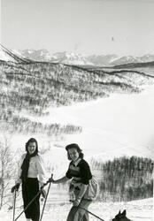 To unge kvinner på ski i vinterlandskap