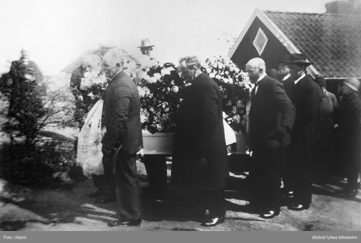 Olivia Jonassen Hjelm begraves fra sitt hjem, Meiseveien 2, Hauge, Rolvsøy i mai 1930. Kista bæres ut fra hjemmet.