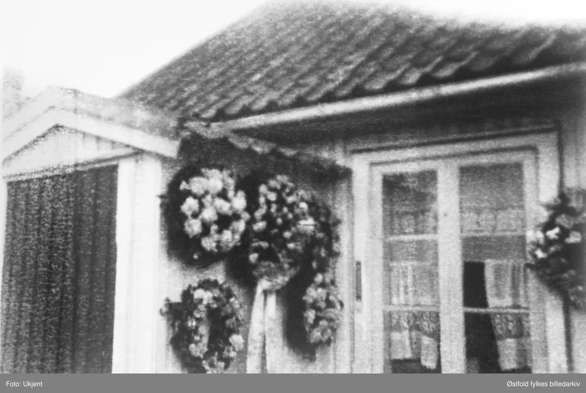 Olivia Jonassen Hjelm begraves fra sitt hjem, Meiseveien 2, Hauge, Rolvsøy i mai 1930. Inngangspartiet pyntet med kranser.