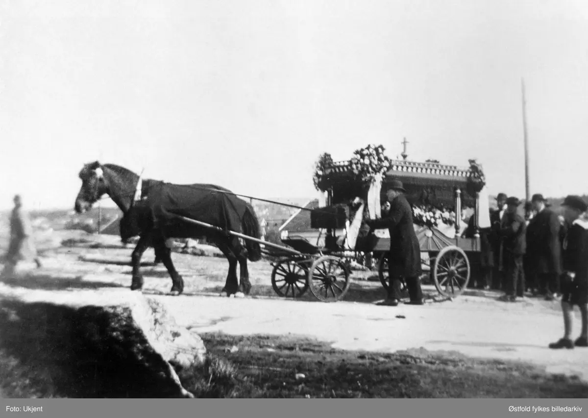Olivia Jonassen Hjelm begraves fra sitt hjem, Meiseveien 2, Hauge, Rolvsøy i mai 1930. Hest med begravelsesvogn og kiste. Gravfølget er på vei til kirka.