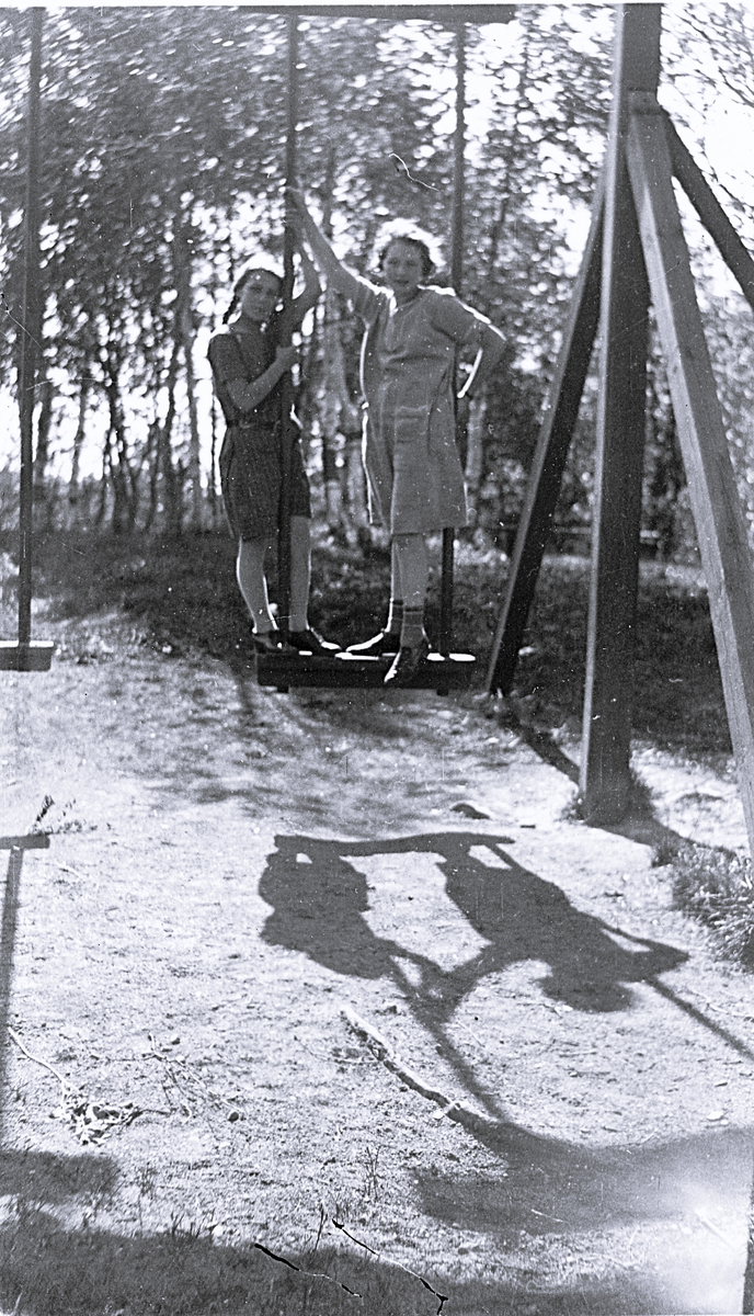 Foto av Inga med en kamrat i Jädraåparken (enligt bildtext i album). Text baksida kort:"Kortet är taget i Jädraåparken 11/6 1926. Jag var då 12 år. Den flickan som är med heter Astrid, kusin till lill Britta".