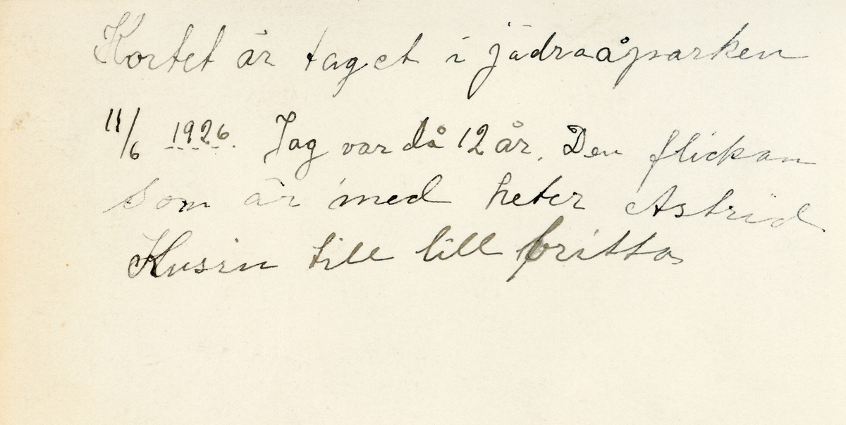 Foto av Inga med en kamrat i Jädraåparken (enligt bildtext i album). Text baksida kort:"Kortet är taget i Jädraåparken 11/6 1926. Jag var då 12 år. Den flickan som är med heter Astrid, kusin till lill Britta".