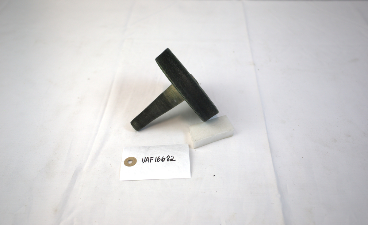 Sirkelformet polerstikkel med utstikkende del. Brukt som poleringsverktøy i gullsmedvirksomhet.